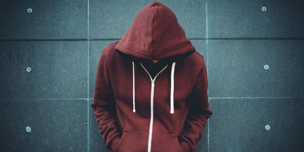 man hiding behind hoodie - Financial Finesse